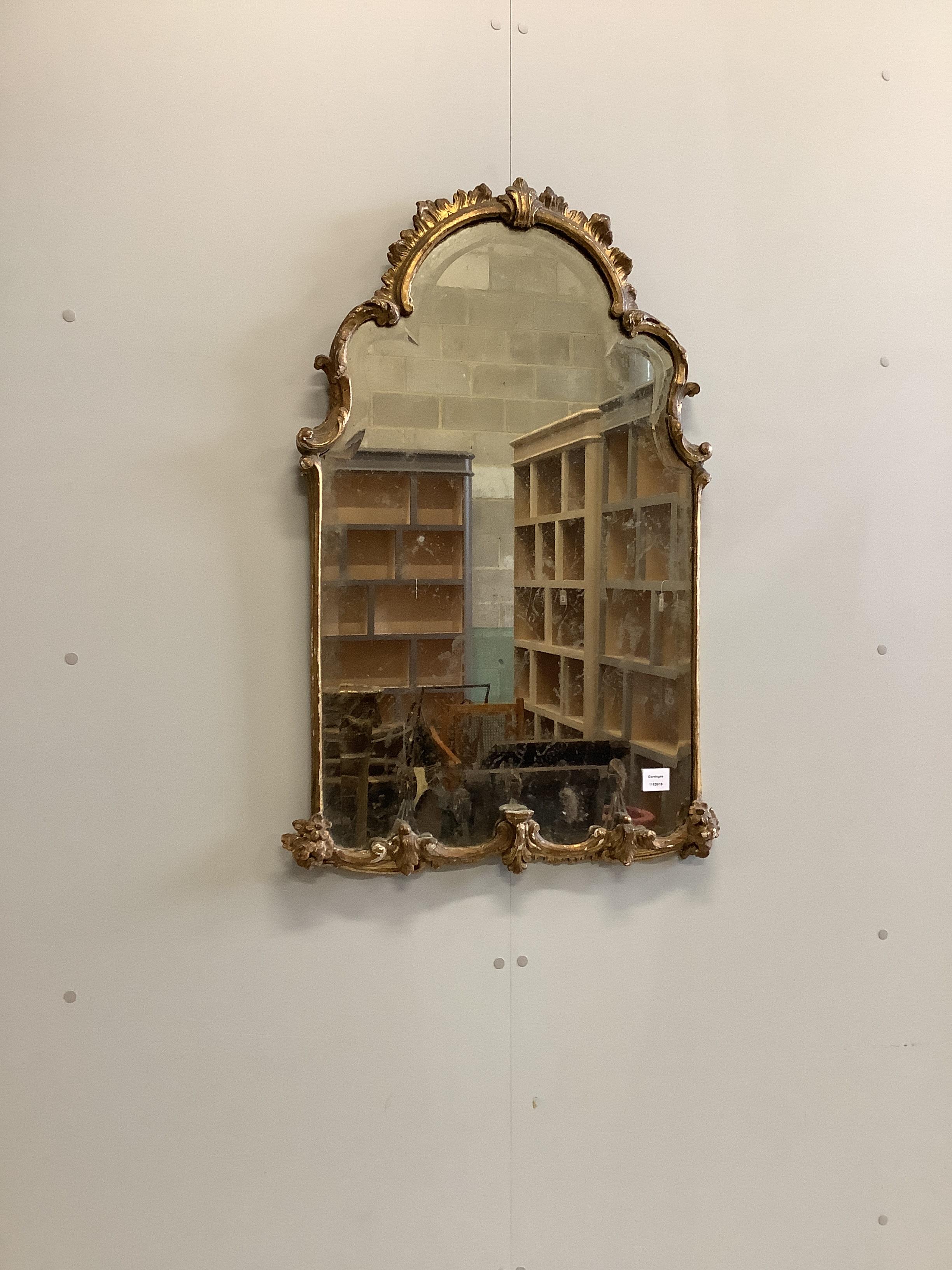 An 18th century giltwood and composition bevelled wall mirror of arched form, width 62cm, height 97cm